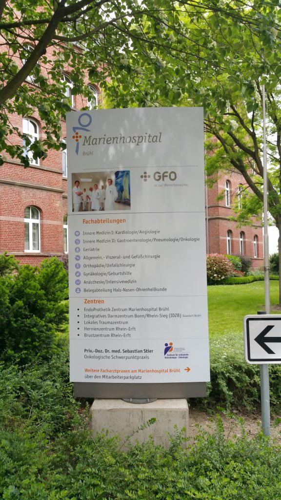 Beschriftete Informationsstele an einem Krankenhaus